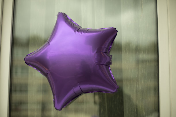 气球明星。紫色的充气球。明星在窗口。图片下载