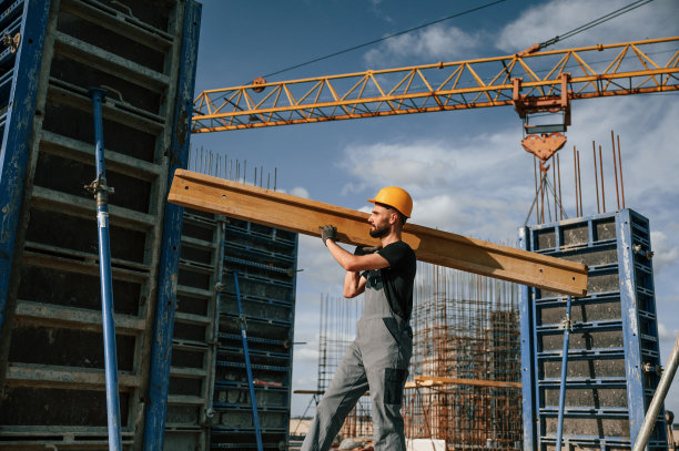 黄色木板。一个穿制服的人正在建筑工地工作图片下载