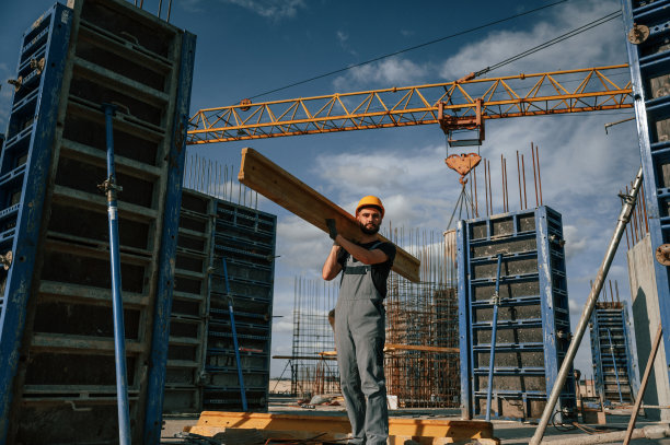 黄色木板。一个穿制服的人正在建筑工地工作图片下载