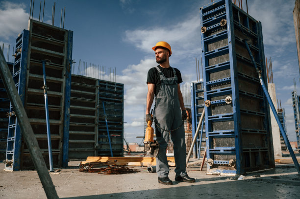 站着，手里拿着磨床。一个穿制服的人正在建筑工地工作图片下载