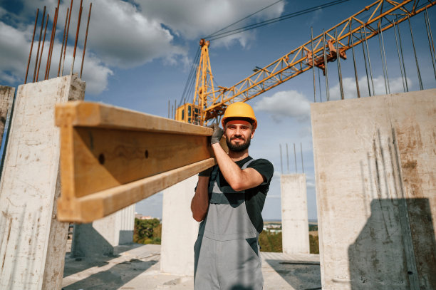 用木板抱着走。一个穿制服的人正在建筑工地工作图片下载