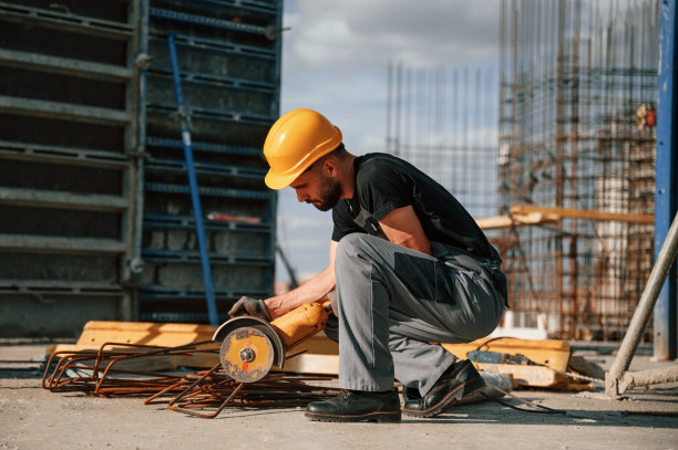用磨床坐削金属件。一个穿制服的人正在建筑工地工作图片下载