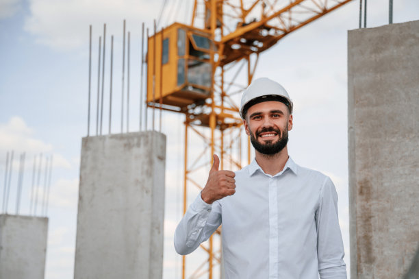 微笑，竖起大拇指。一个穿制服的人正在建筑工地工作图片下载