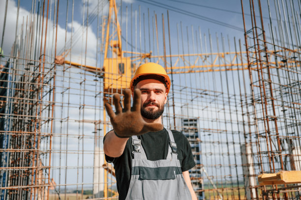 封闭区域。停止动作。一个穿制服的人正在建筑工地工作图片下载