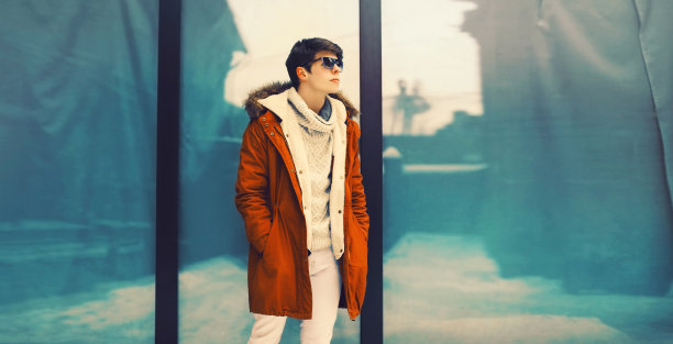 时髦的年轻人穿着夹克在城市里摆姿势图片下载