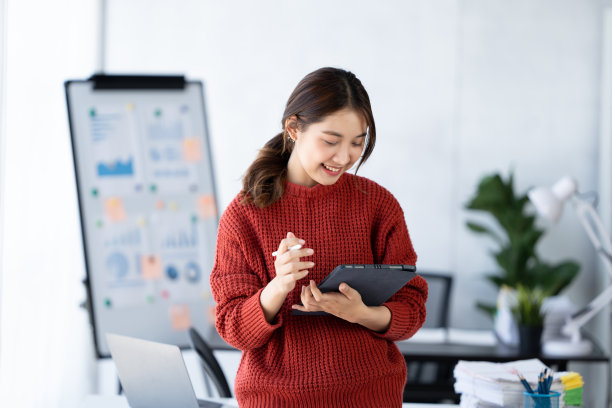 亚洲女人笑着开心地用平板电脑开会上班图片下载