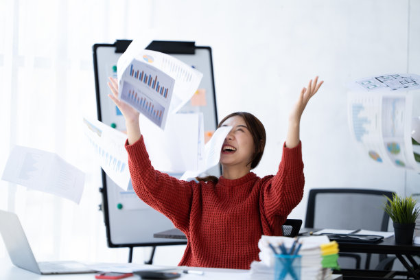 这女孩感到从工作中解脱出来了。一个穿红衫的女人坐在办公室里。图片下载