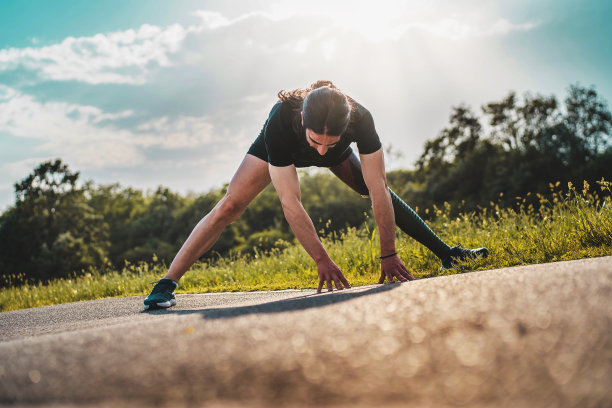 戴着假肢的年轻运动员在公园里做伸展运动图片下载