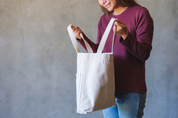 特写图像的年轻女子拿着和携带一个白色的白色布袋可重复使用和环保的概念图片下载