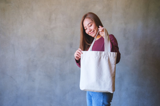 肖像形象的年轻女子持有和携带一个白色布袋可重复使用和环保的概念图片下载