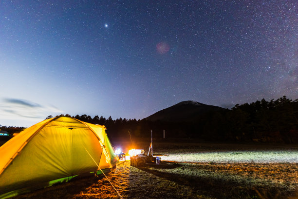 营地的场景下，一个清晰的星星夜空与木星和银河图片下载