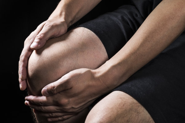 一个关节疼痛的男人抱着他的膝盖。图片下载