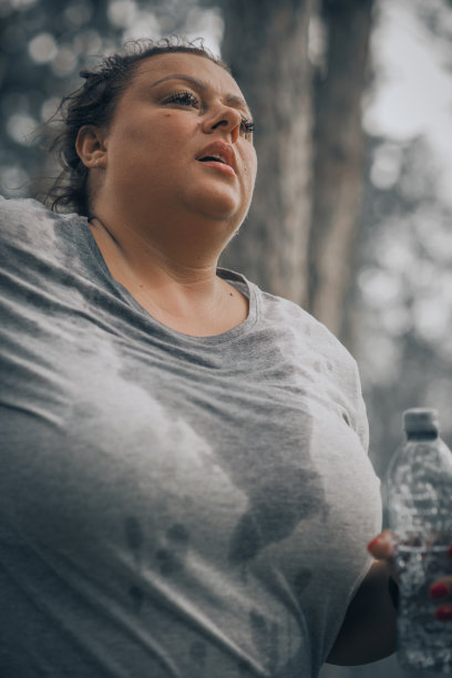 一个大汗淋漓的大码女人慢跑的特写图片下载