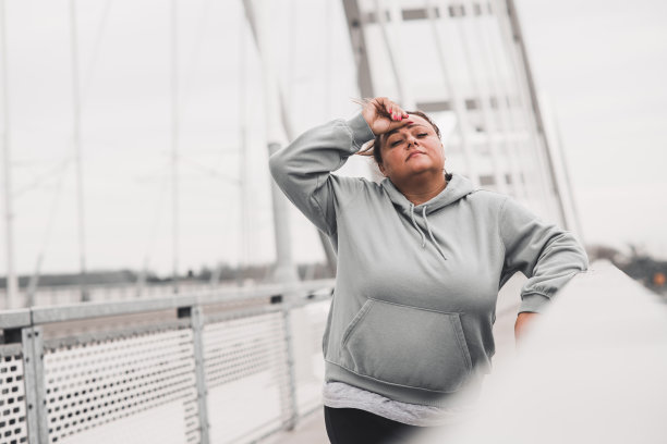 肥胖的拉丁妇女在跑步后试图喘口气图片下载