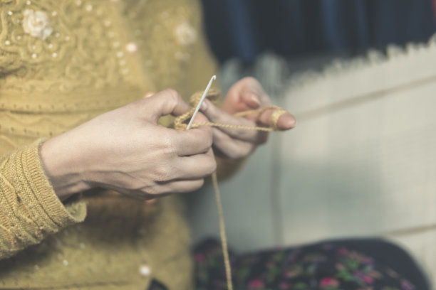 特写妇女的手在家里编织。图片下载