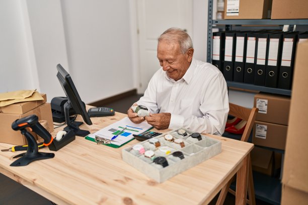 高级男子电子商务工作人员在办公室拿着手表图片下载