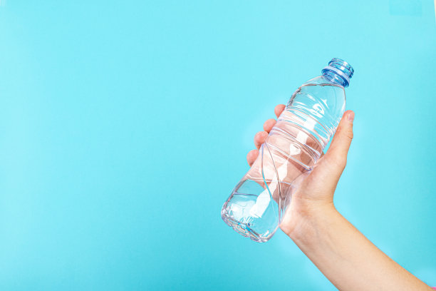 在蓝色背景下，手拿着一个水瓶图片下载