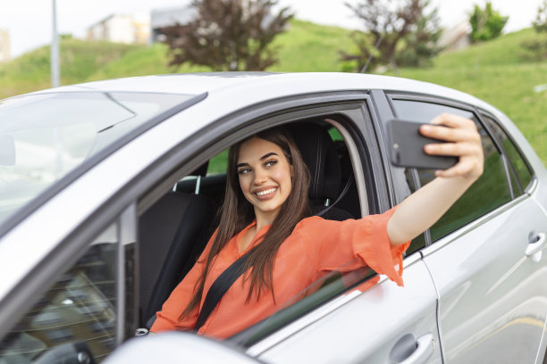 微笑的年轻女子在户外用智能手机相机自拍照片。度假旅游概念——微笑的少女在户外用智能手机相机自拍图片下载