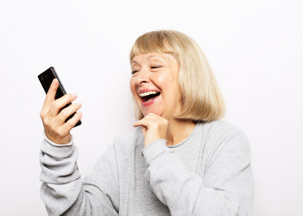 老妇人在网上看有趣的视频。图片下载