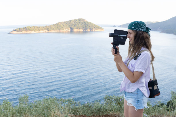 一个十几岁的女孩正在用一台复古相机拍摄图片下载