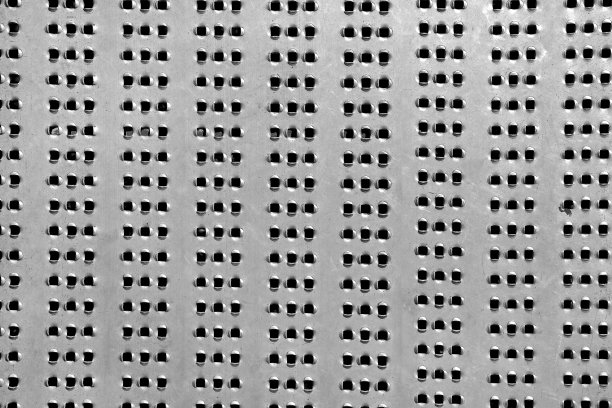 金属带孔板用于装饰地板或墙壁，穿孔钢表面金属质感背景特写视图。图片下载