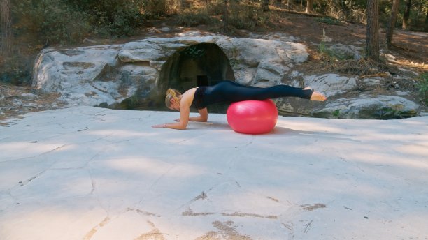 一名女子在公园里用健身球锻炼身体图片下载
