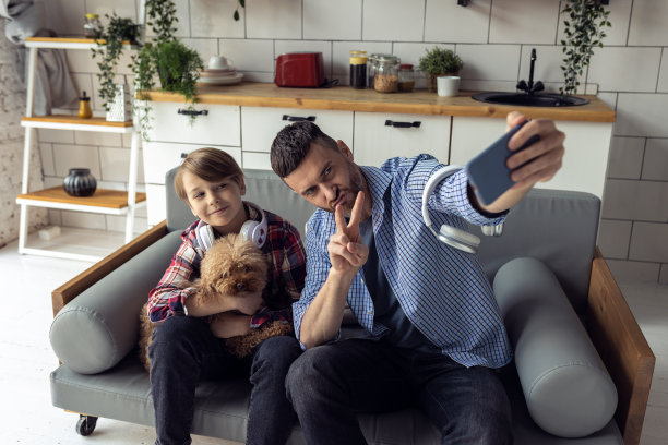 英俊的年轻父亲和他十几岁的儿子一起度过美好的时光。在社交媒体上拍照、自拍。家庭时间，玩得开心，享受。父亲,育儿的概念。两代人图片下载