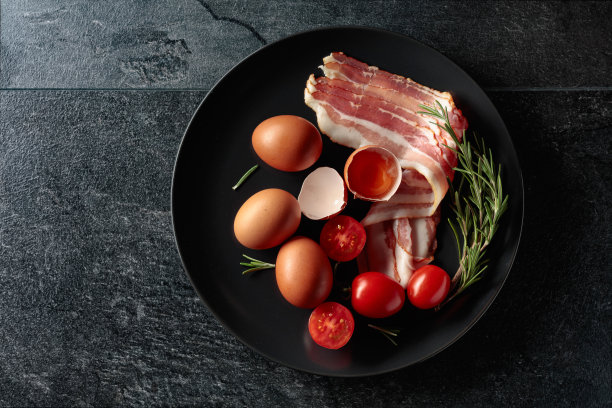 熏肉配鸡蛋，西红柿和迷迭香。图片下载