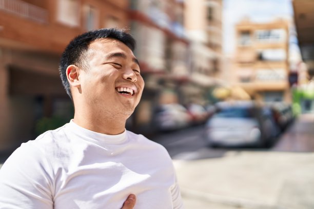 年轻的中国男子自信地微笑着站在街上图片下载