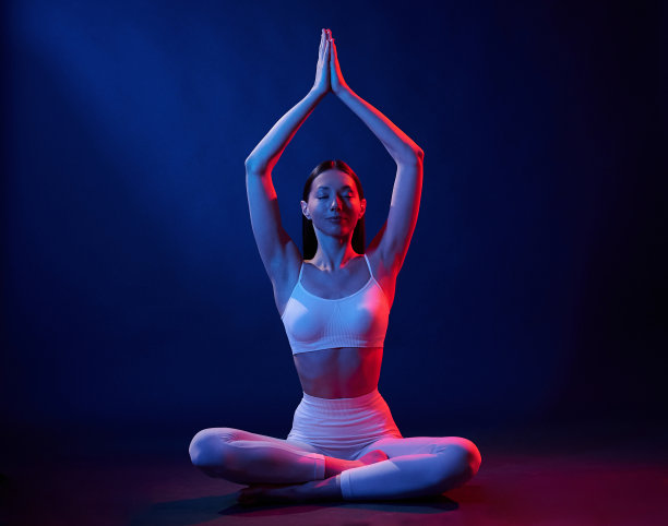 莲花。身着运动服的年轻女子在霓虹灯的演播室里图片下载