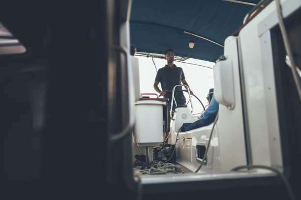 年轻的船长在掌舵帆船图片下载