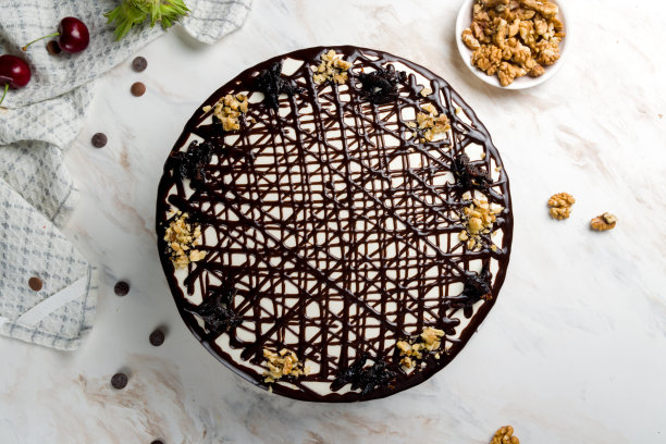 蛋糕与梅干和核桃倒入巧克力白色大理石桌面视图图片下载