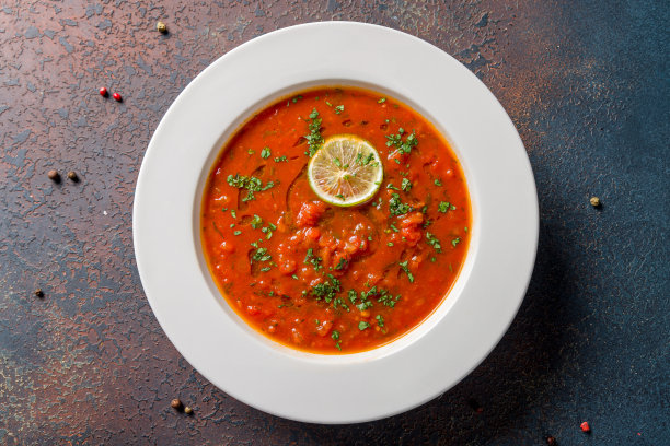 汤奶油番茄在盘子上的深色石头桌面视图图片下载