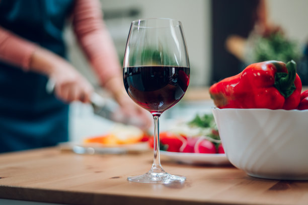 红酒装在杯子里，放在厨房柜台上图片下载