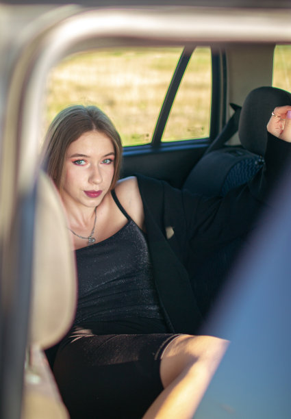 一个体贴的漂亮的棕色头发的斯拉夫女孩穿着黑色衣服坐在车里图片下载