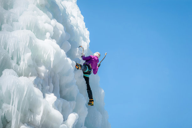冰冻瀑布上的登山女性图片下载