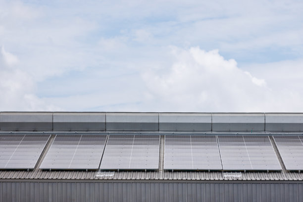 蓝色天空的工业工厂屋顶太阳能电池板。图片下载