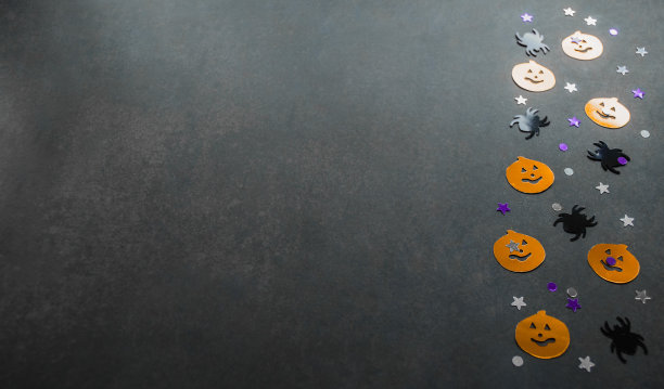 万圣节背景:橙色南瓜、黑色蜘蛛和星星形状的五彩纸屑。灰色的背景。本空间图片下载