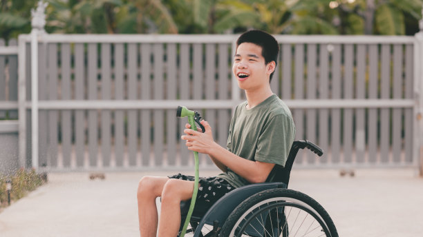 残疾青年在轮椅上的户外活动。图片下载