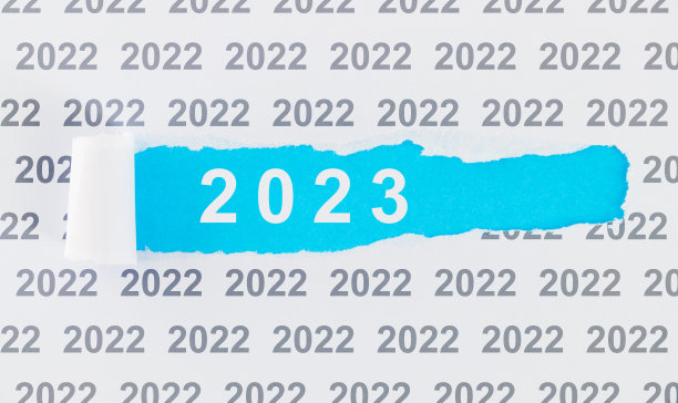 撕破的纸上写着2022年被2023年取代图片下载