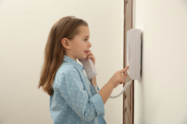 可爱的小女孩在室内接听对讲机电话图片下载