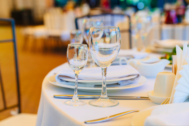 白桌布的圆桌上放着空酒杯。图片下载