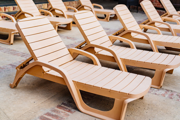 泳池边的空日光浴床。花园和娱乐区的家具。图片下载