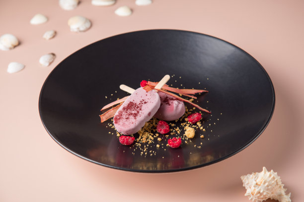 黑色的盘子，布拉塔奶酪和水果沙拉，一个圆形的深色盘子，在深色的背景。图片下载