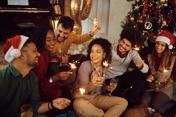 快乐的朋友在家里玩烟花。图片下载