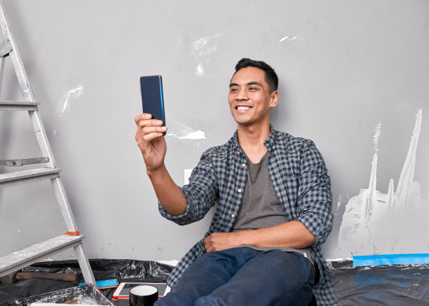 一名年轻的亚洲男子在忙着DIY家居装修项目时自拍图片下载