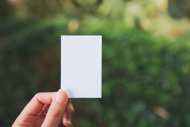 女人的手拿着一张空白的小白纸，用来添加文字。图片下载