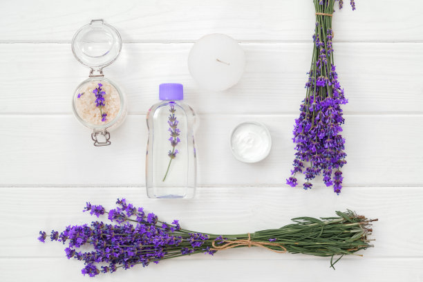 草药油和薰衣草花在白色的木制背景图片下载