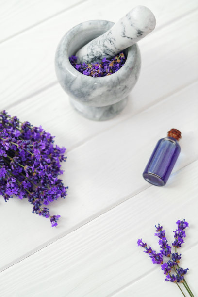 草药油和薰衣草花在白色的木制背景图片下载