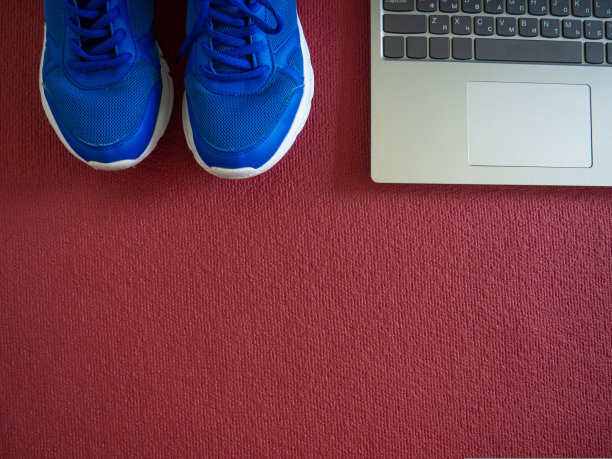 运动鞋，笔记本电脑放在红色瑜伽垫上图片下载